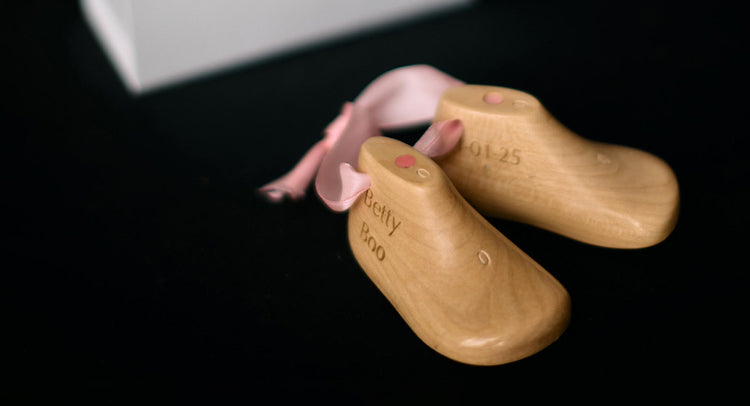 Small pair of baby shoe lasts with engraving and pink ribbon
