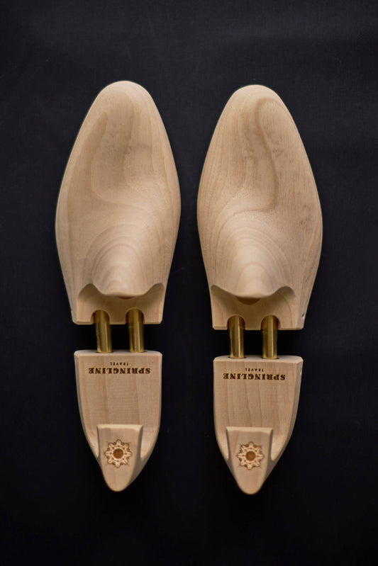 A pair of natural wooden shoe trees with the brand name 'Springline' inscribed on the side.